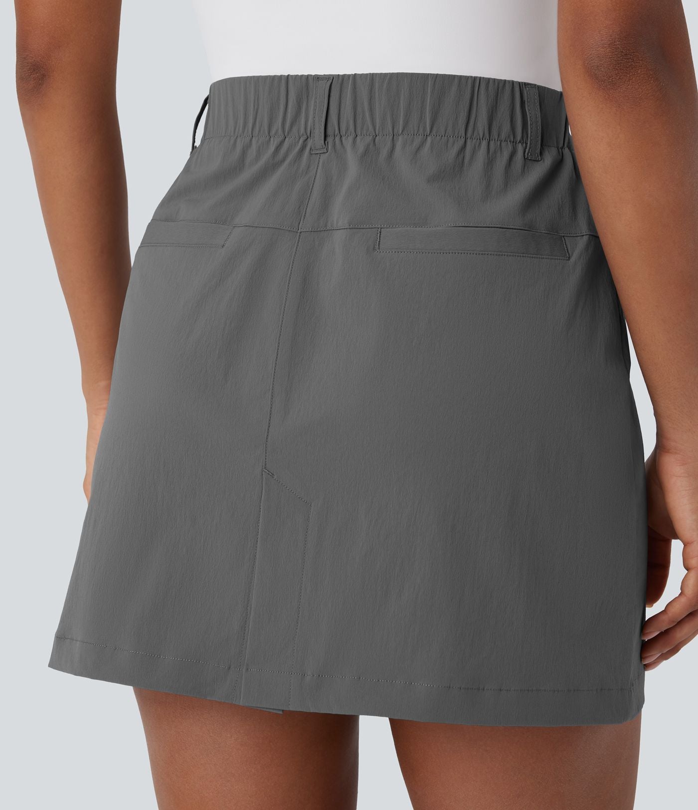 Jupe courte de golf ligne A taille haute avec boutons, zip, poches latérales et fente