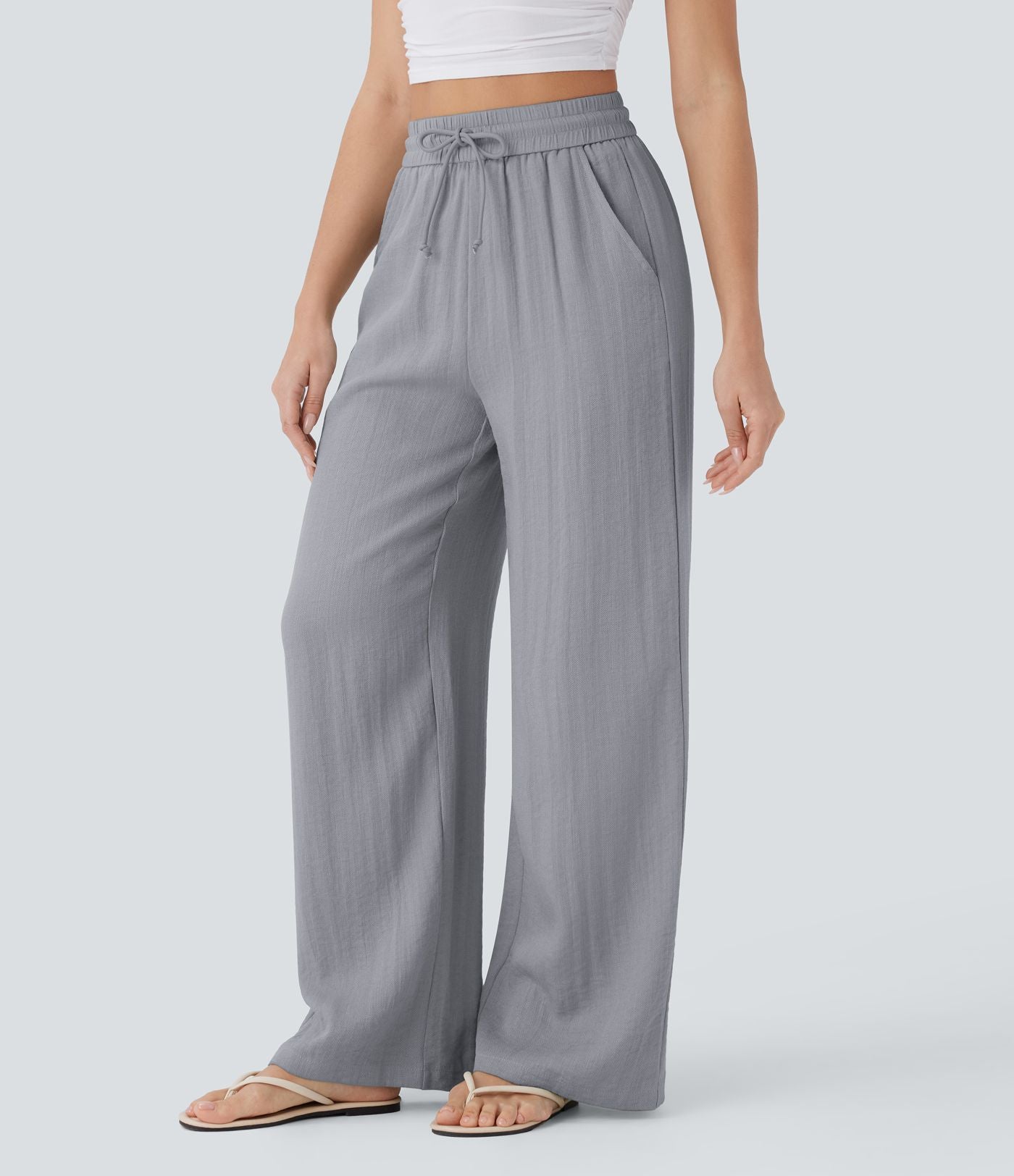 Pantalon large fluide taille haute avec cordon de serrage, poches latérales et aspect lin