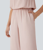 Combinaison pantalon tailleur jambes larges col montant dos goutte d'eau manches courtes avec poches latérales