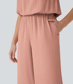 Combinaison pantalon tailleur jambes larges col montant dos goutte d'eau manches courtes avec poches latérales