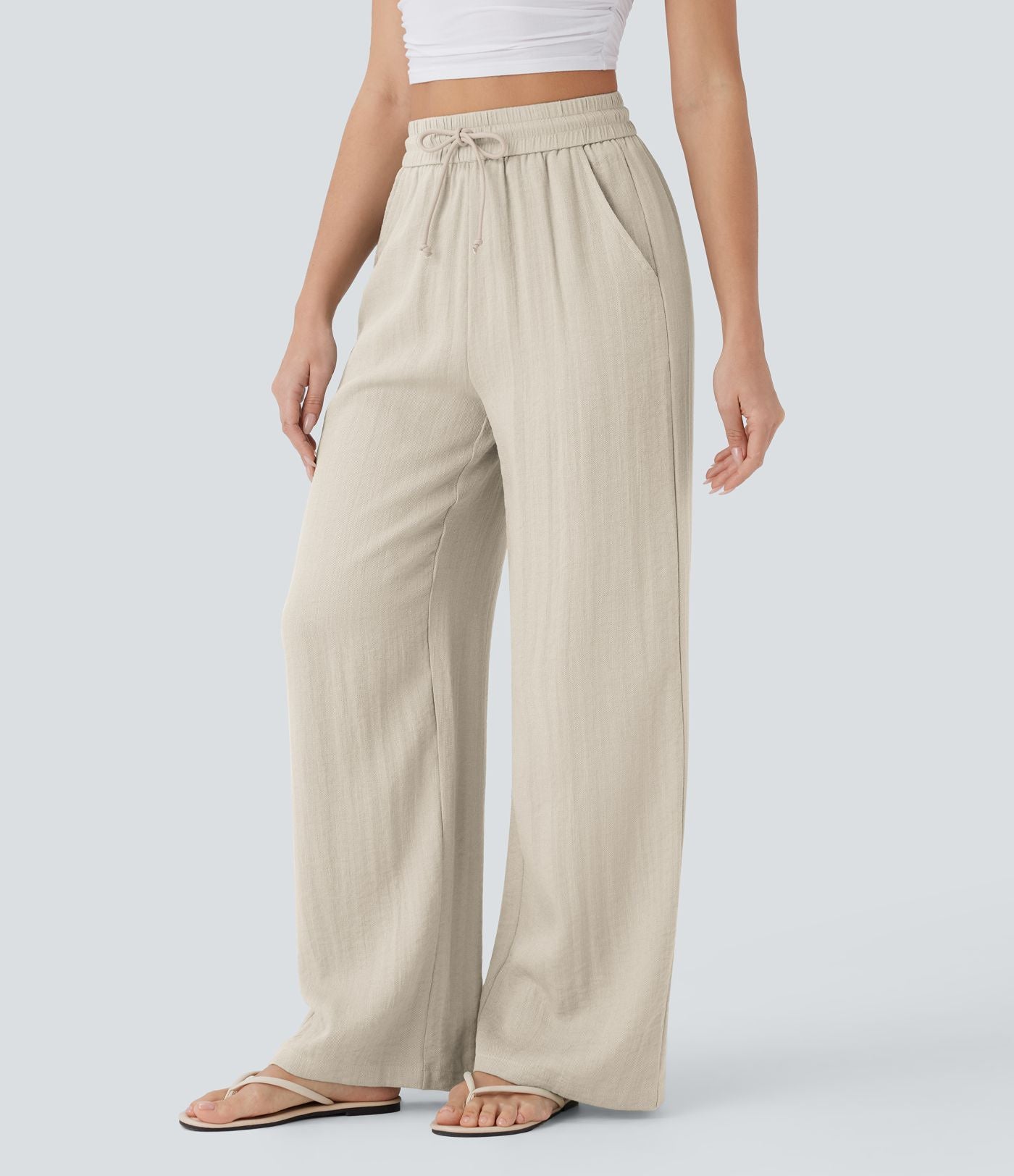 Pantalon large fluide taille haute avec cordon de serrage, poches latérales et aspect lin
