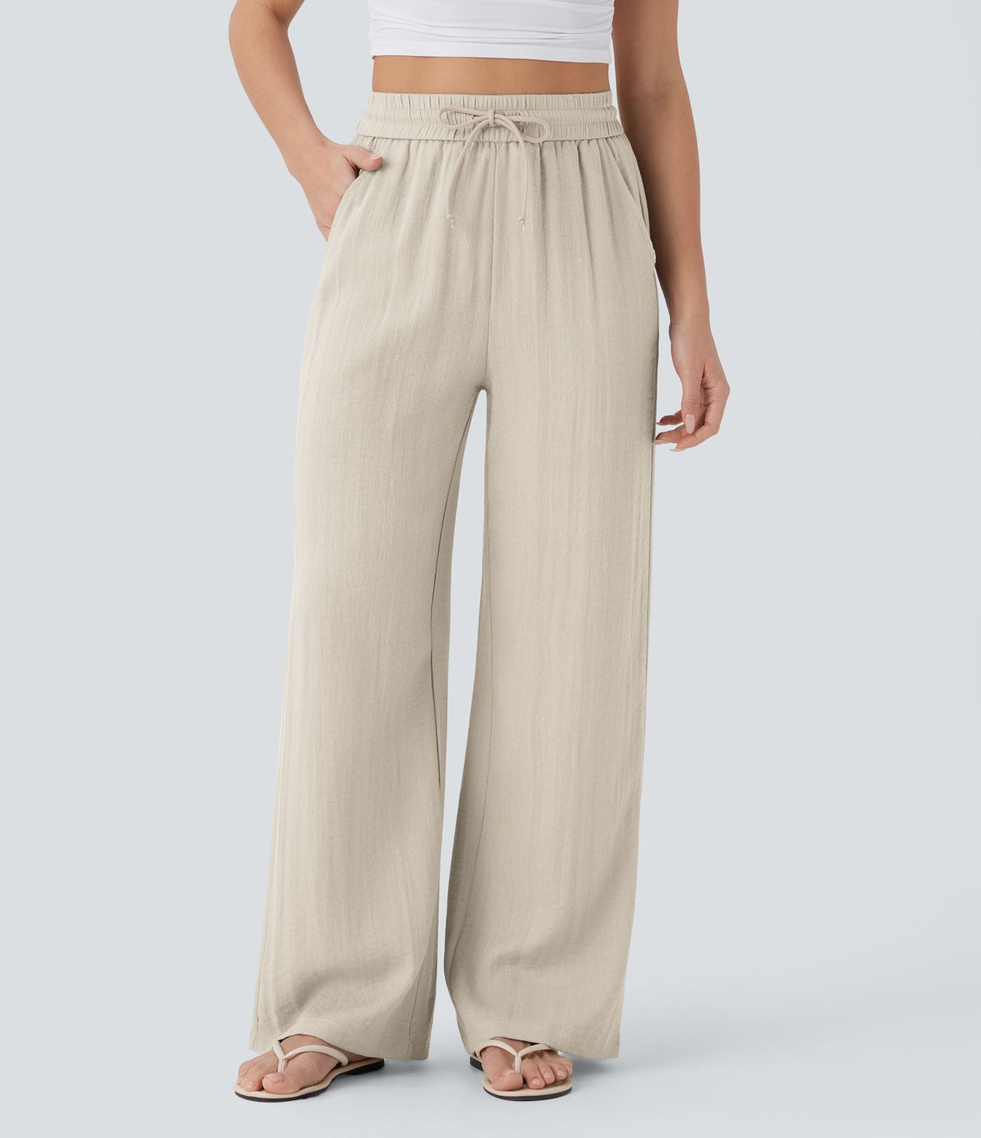 Pantalon large fluide taille haute avec cordon de serrage, poches latérales et aspect lin